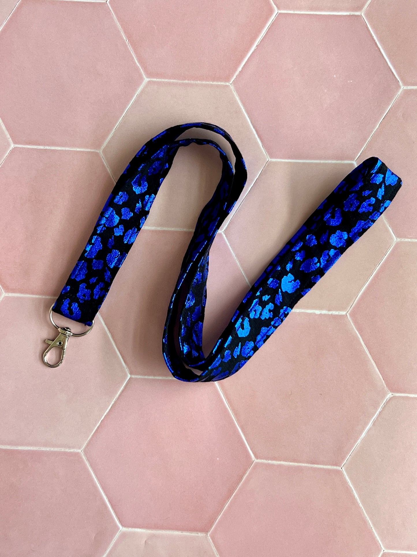 Flat lay of bold black and blue foil leopard lanyard, handmade cotton fabric with D-ring attachment, ideal gift UK