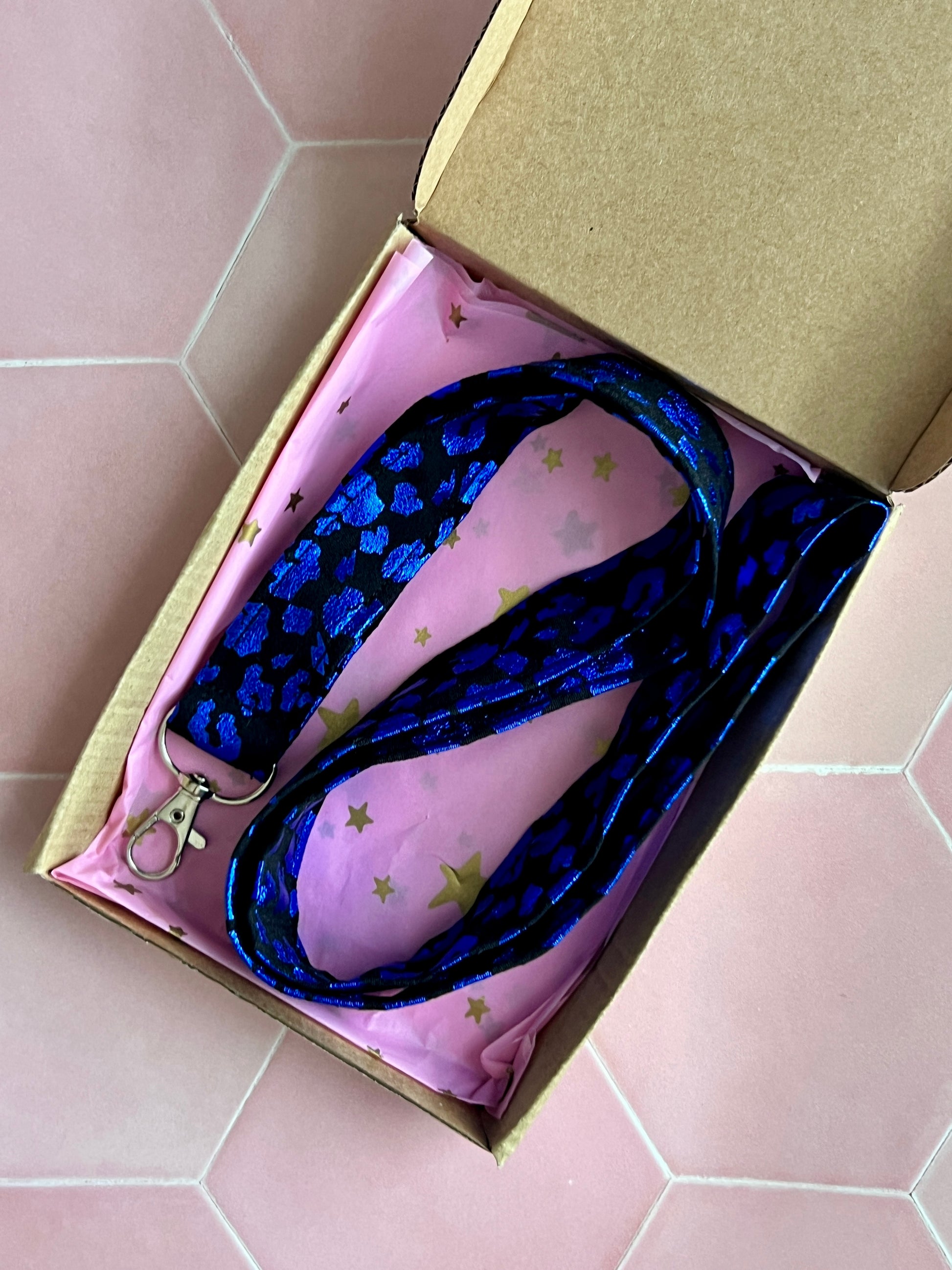 Foil leopard print lanyard with black and blue shimmer, presented in eco-friendly kraft gift box with pink star wrapping