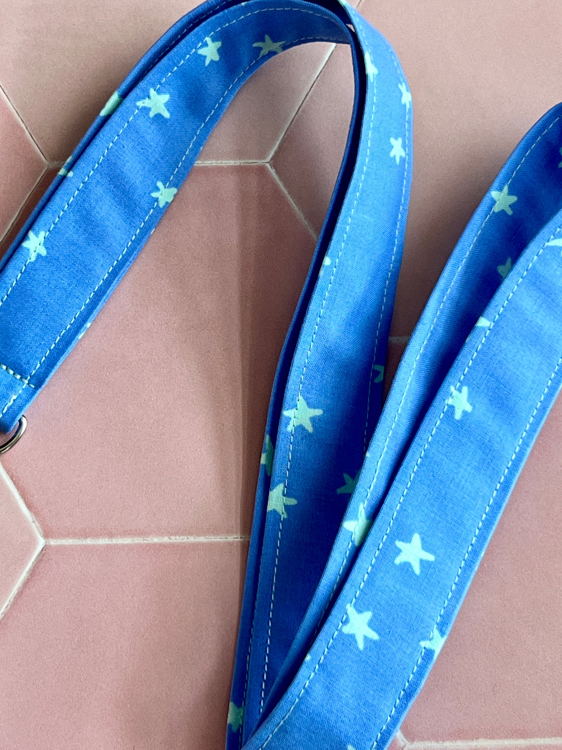Close-up of blue star print lanyard, handmade for securing keys and ID cards, soft cotton fabric design UK