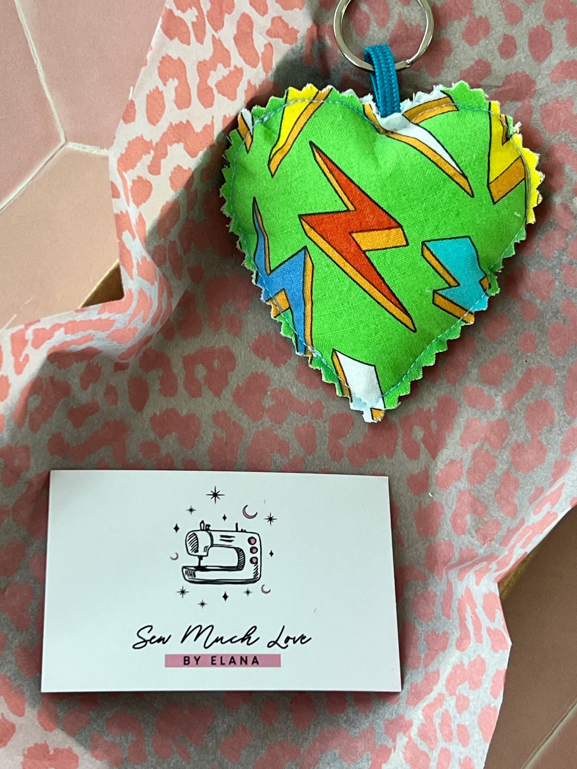 Green Thunderbolt Fabric Heart Keyring, has a green background with multicoloured thunderbolts