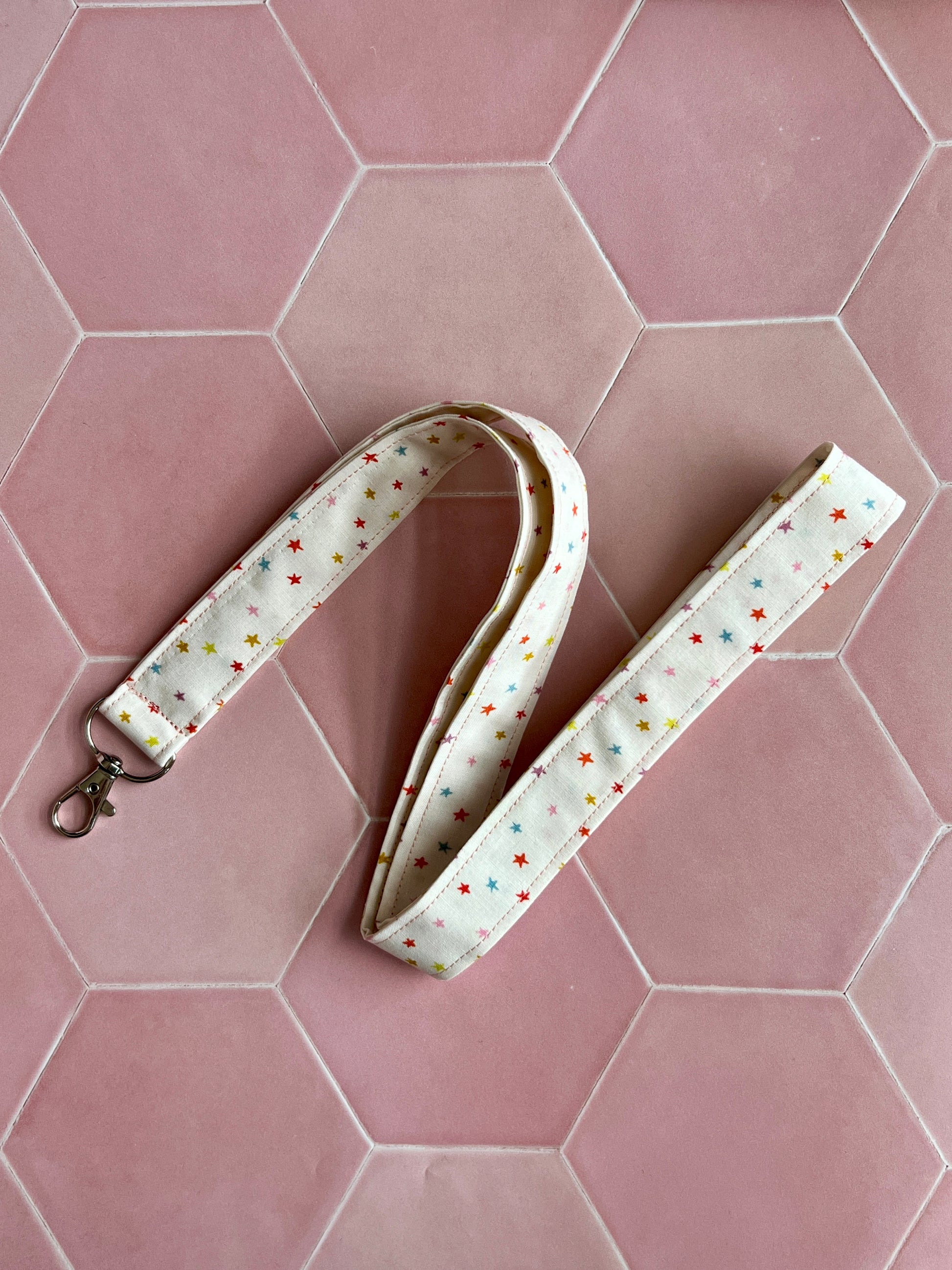 Fabric lanyard with multicoloured mini stars on cream background, handmade in the UK, perfect for keys and work badges