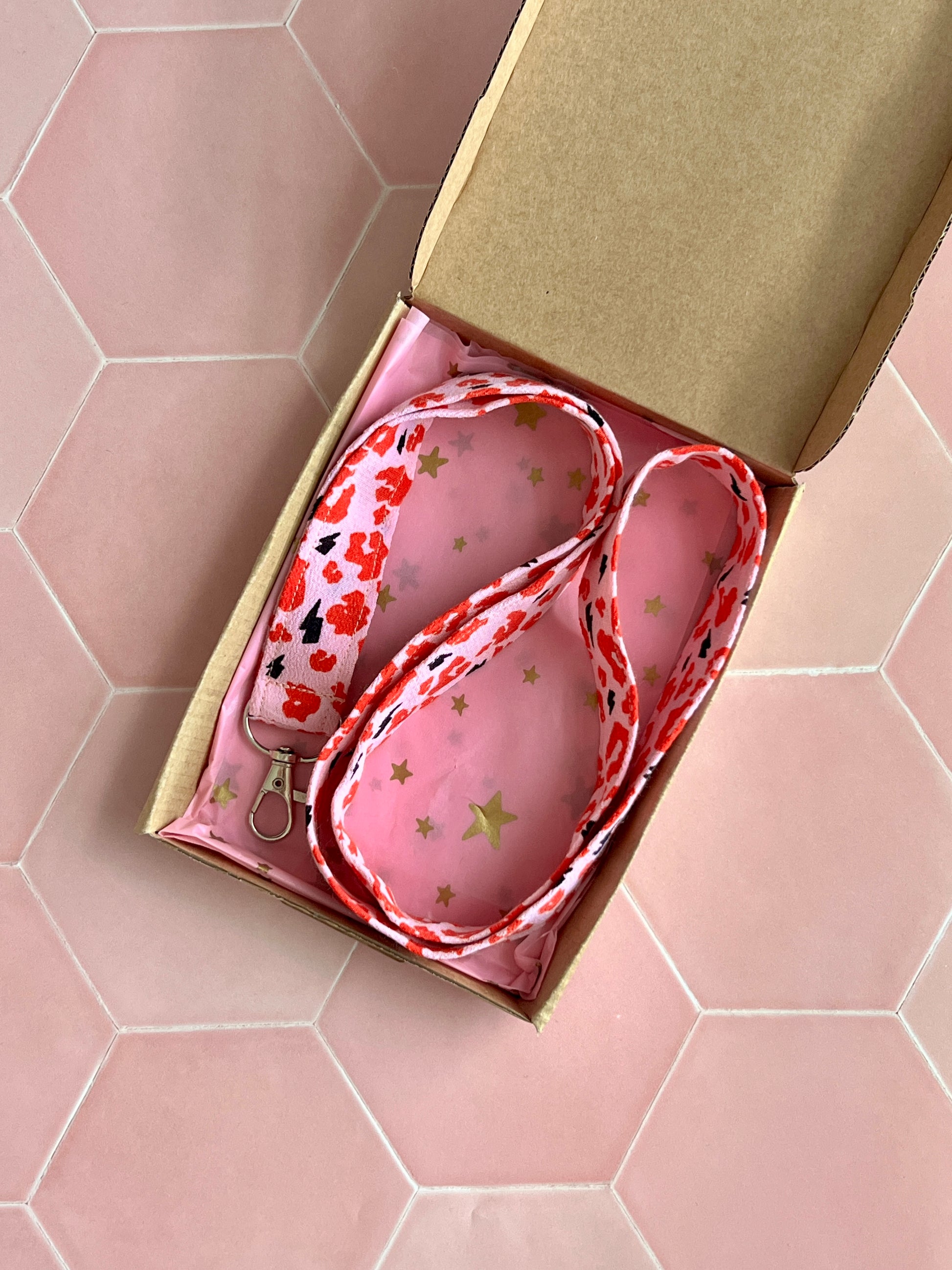 Handmade bold leopard print lanyard with D-ring clasp, wrapped in pink starry tissue inside a kraft gift box