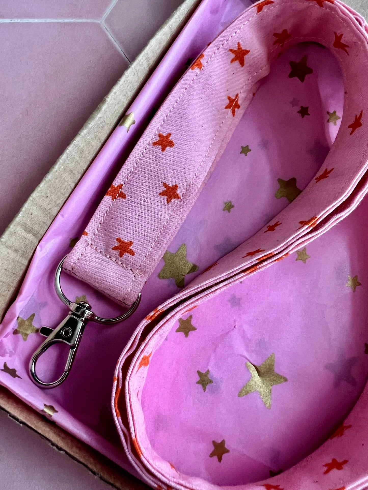 Close-up of pink and orange star print lanyard, handmade gift for teachers and students, packed in pink starry tissue and kraft box